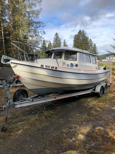 Cabin cruiser on trailer at boatyard, ready for pre-purchase survey in Southeast Alaska.