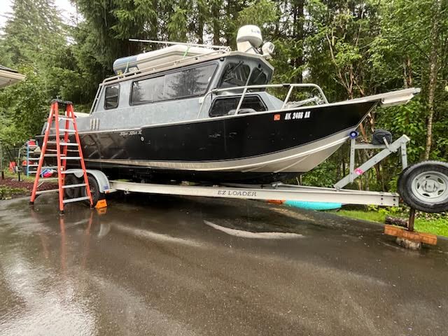 Aluminum cabin boat on trailer during pre-purchase inspection prep.